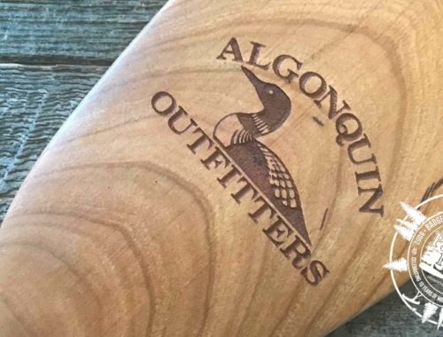 Algonquin Outfitters logo laser engraved on the tip of a cherry Badger canoe paddle