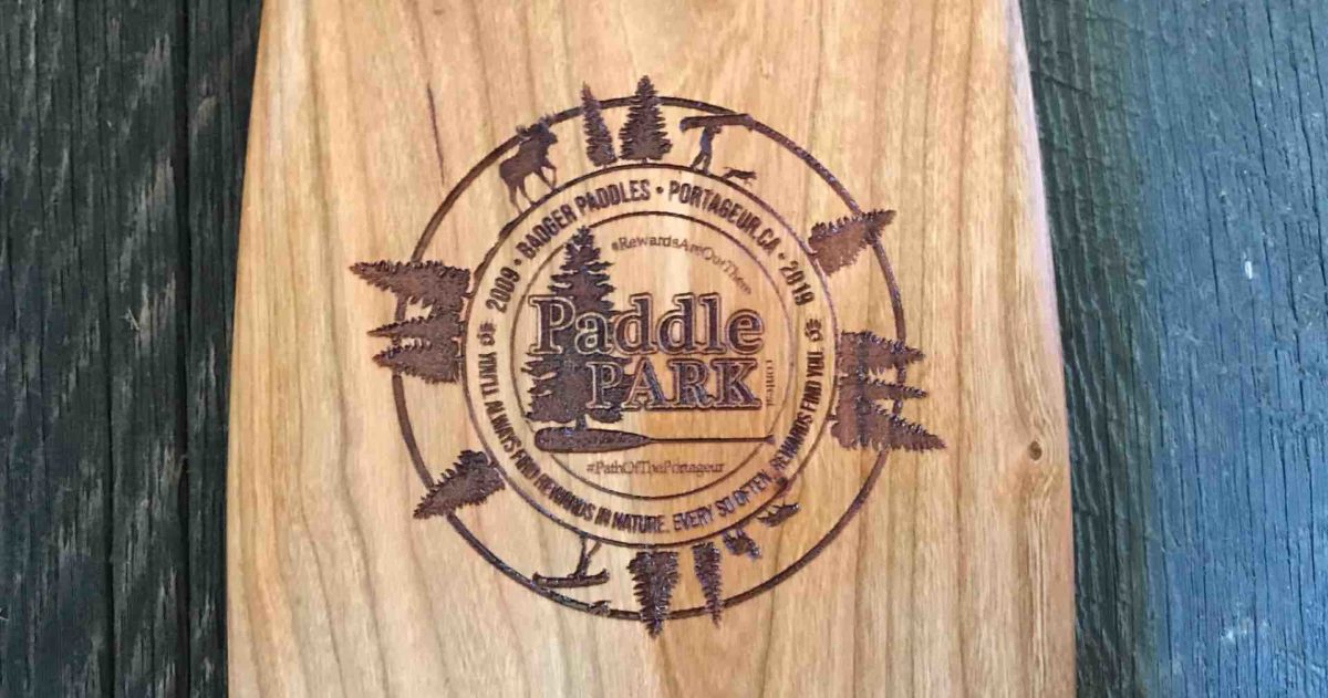 laser engraved logo on a solid wood cherry canoe paddle depicting the Paddle in the Park Contest anniversary logo for 2019