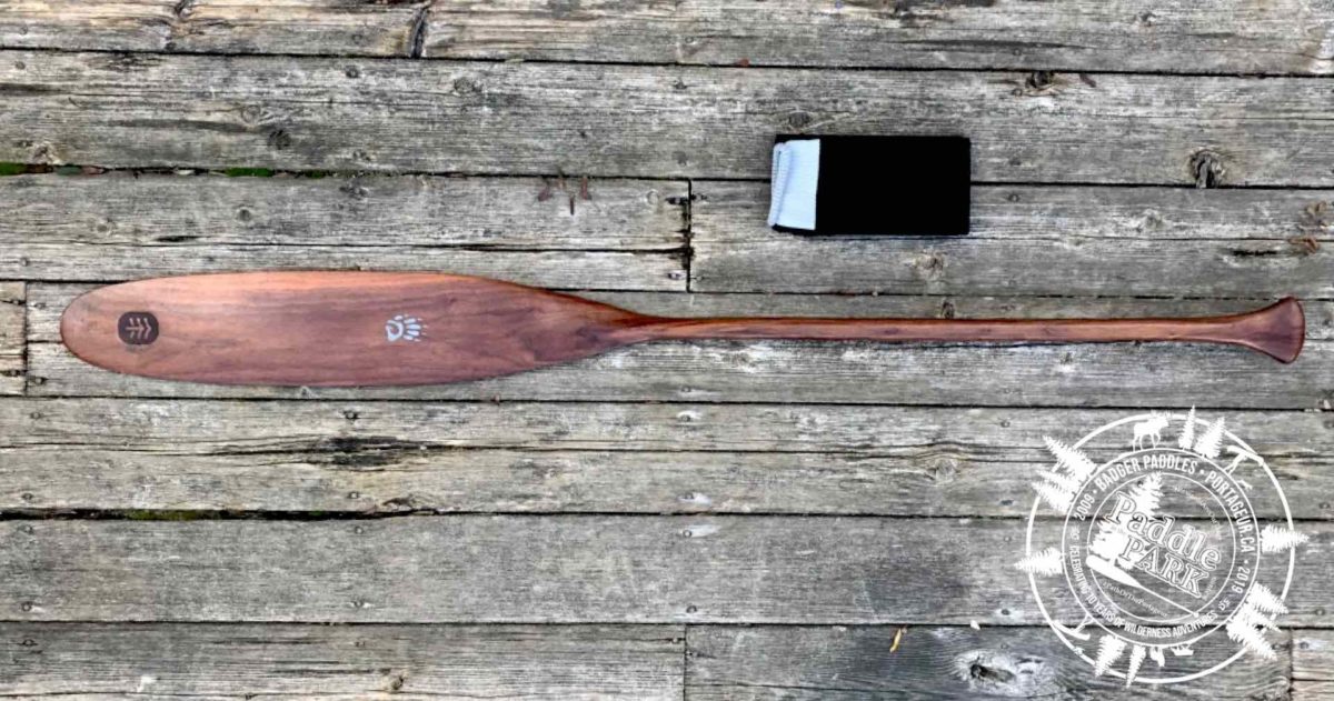 Special Edition Limited Issue Walnut Badger Canoe Paddle with folded paddle sock on rustic wood background