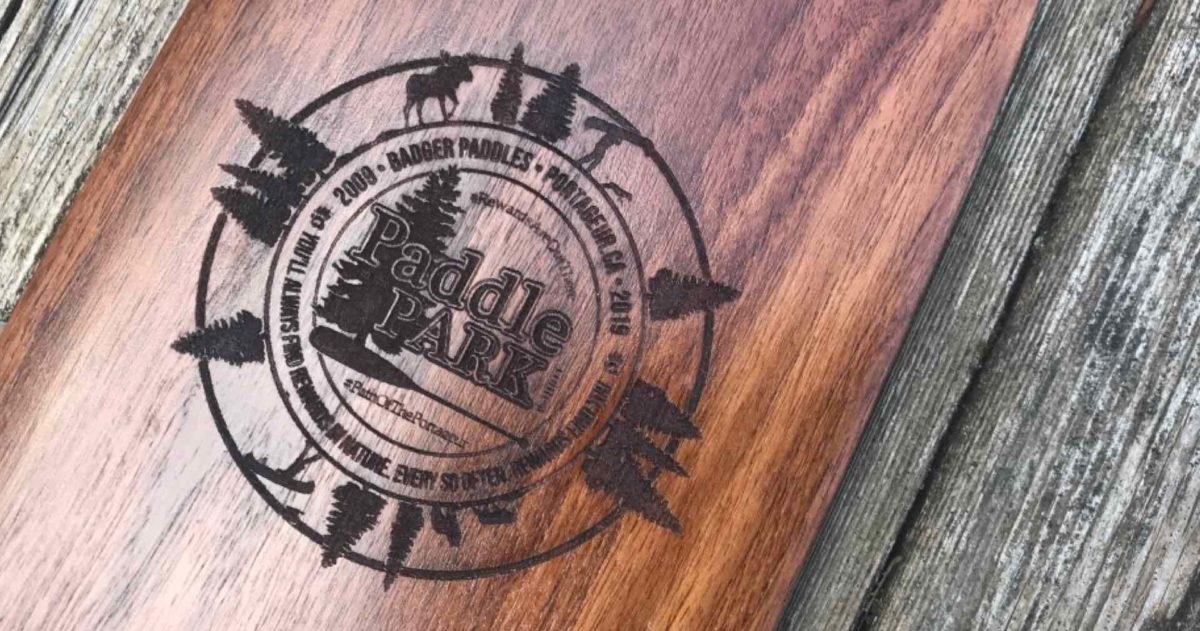 Special Edition Limited Issue Walnut Badger Canoe Paddle with laser engraved Paddle in the Park Contest logo on rustic wood background