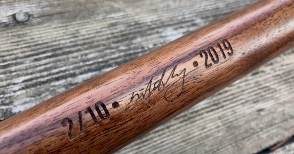 Special Edition Limited Issue Walnut Badger Canoe Paddle close up of shaft - numbered, signed and dated engraved on rustic wood background