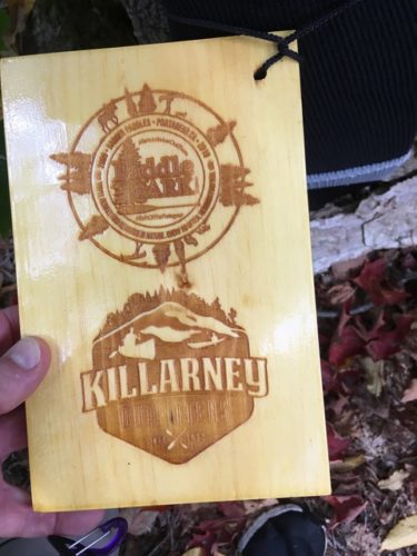 wooden tag depicting laser engraved Paddle in the Park Contest and Killarney Outfitters logos in pine