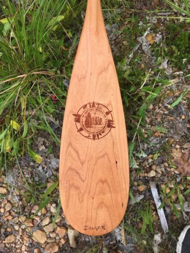 Cherry LaBonga canoe paddle with grass and stones - with laser engraving of Paddle in the Park Contest logo