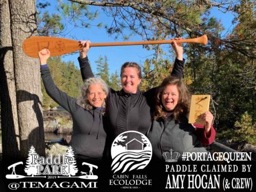 Amy Hogan and crew holding the Badger PORTAGE QUEEN LaBonga paddle she won as part of the Cabin Falls EcoLodge canoe paddle and prize package he won from the Paddle in the Park Contest