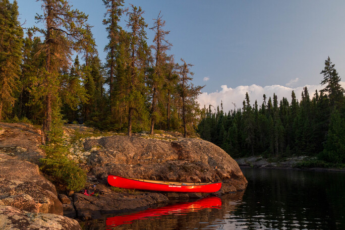 Red canoe on a rocky shore